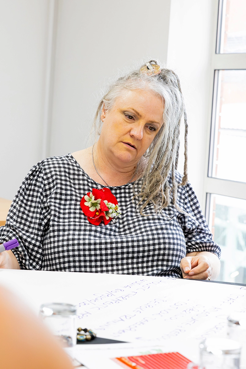 Person writing on flipchart paper during a workshop.