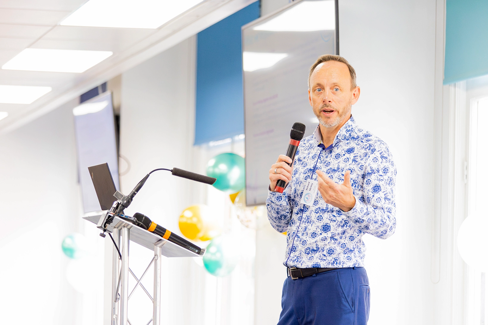 Person giving presentation at a podium with a microphone.