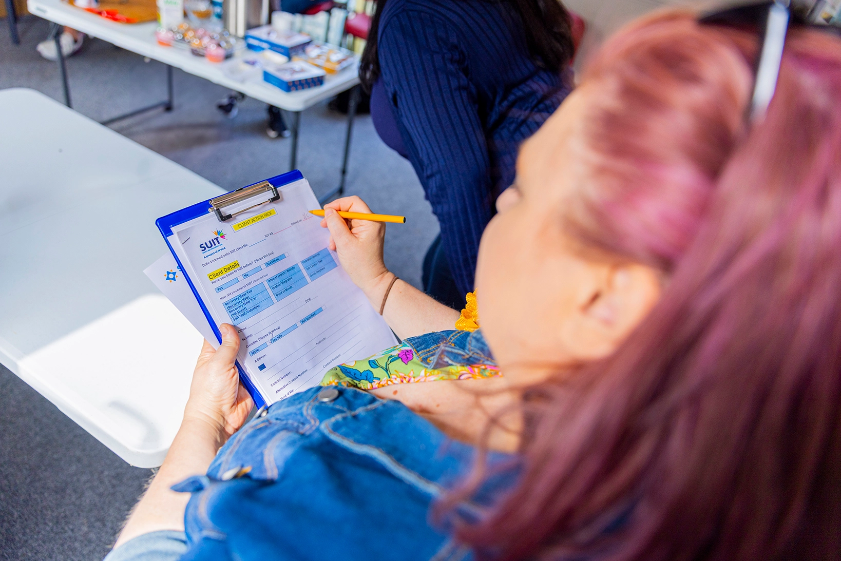 Person completing a worksheet on a clipboard.